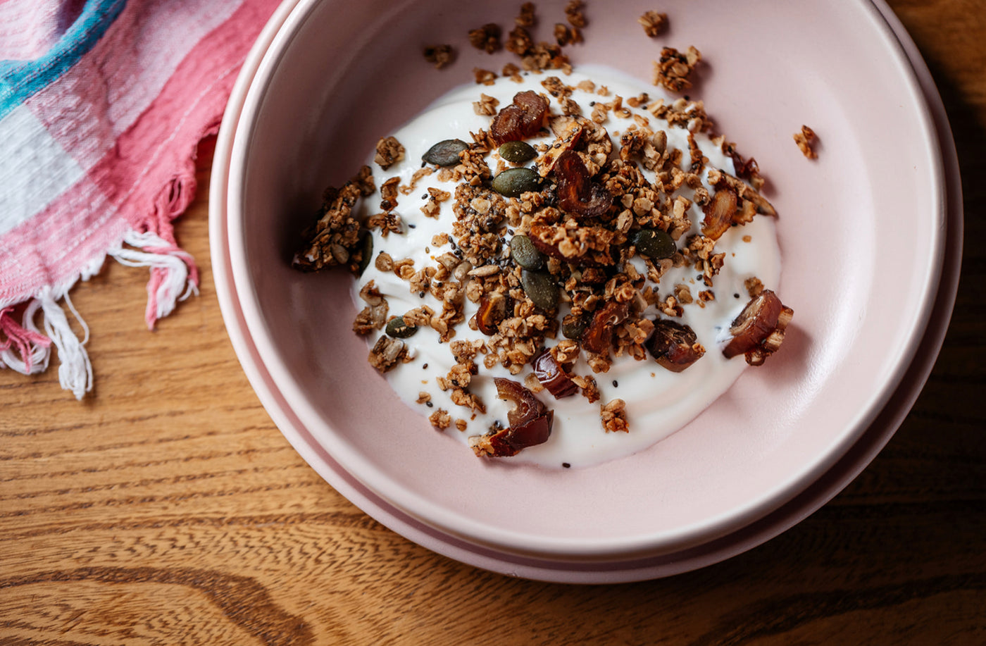 A bowl of Greek yoghourt and Just So Good’s Almond & Date granola. Made with oats, whole almonds, organic sunflower & pumpkin seeds, chia seeds, dates, mixed spice, organic honey, organic virgin coconut oil. A high fibre, nutritious breakfast.